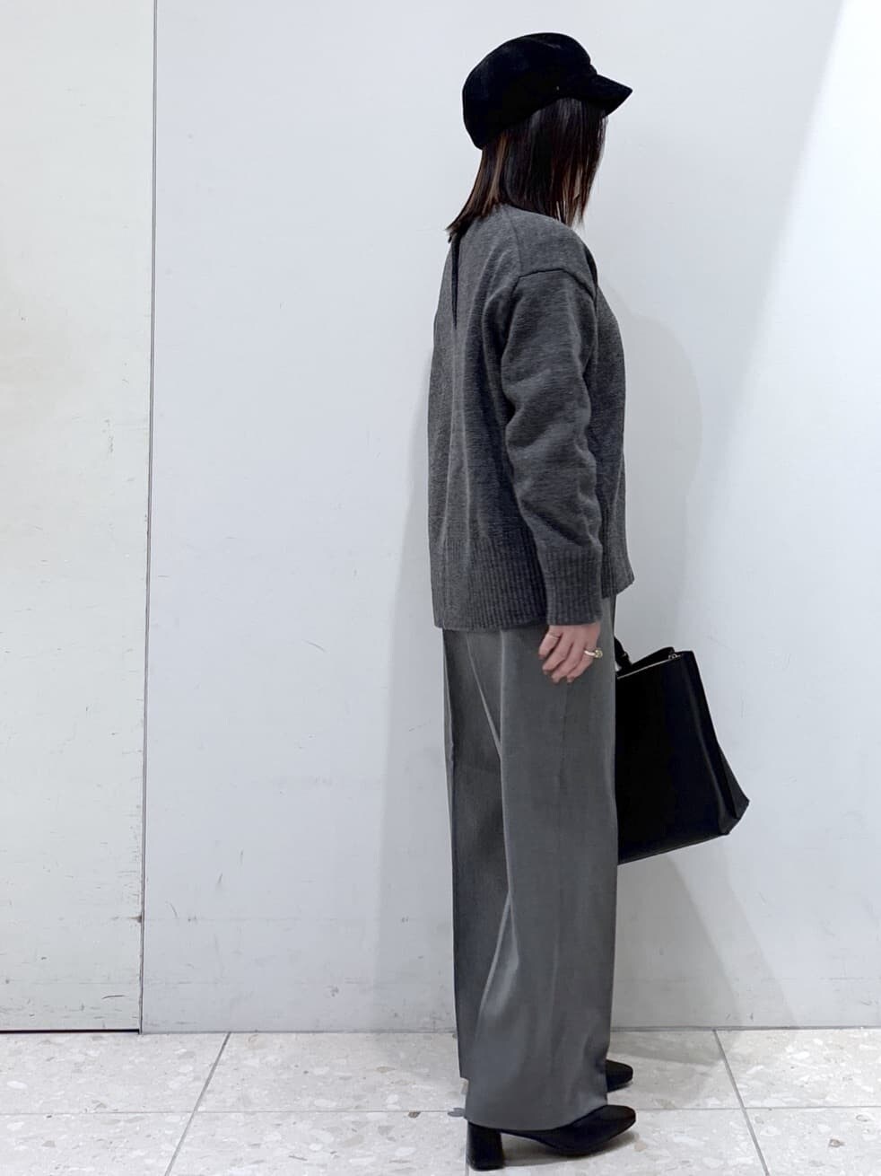 グレー系のニット/セーター、ホワイト系のTシャツ/カットソー、グレー系のその他パンツを着用したレディースの冬コーディネートの2枚目の写真