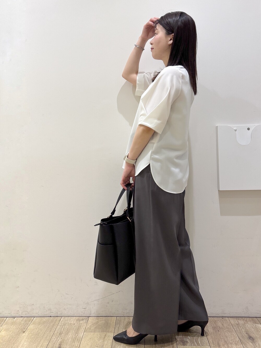 ブラック系のトートバッグ、ブラック系のパンプス、ホワイト系のシャツ/ブラウスを着用したレディースの春コーディネートの4枚目の写真