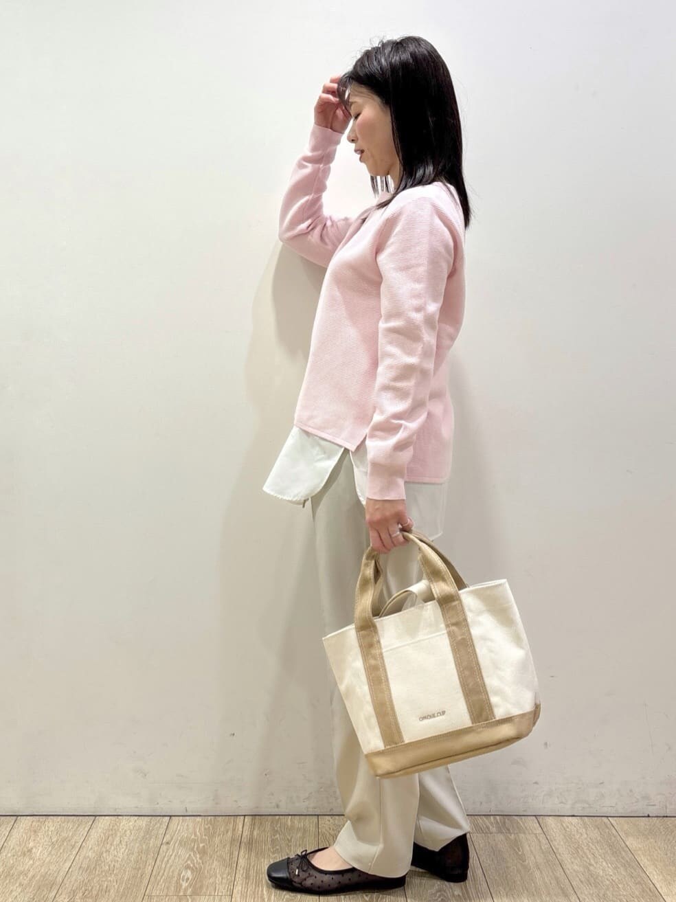 ブラック系のパンプス、ピンク系のニット/セーター、イエロー系のTシャツ/カットソーを着用したレディースの春コーディネートの3枚目の写真