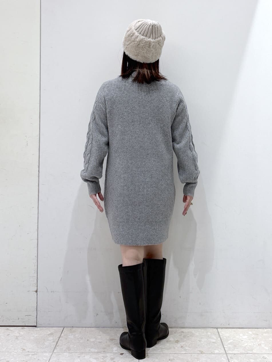 グレー系のワンピース、ブラック系のハンドバッグ、ブラック系のブーツを着用したレディースの冬コーディネートの4枚目の写真