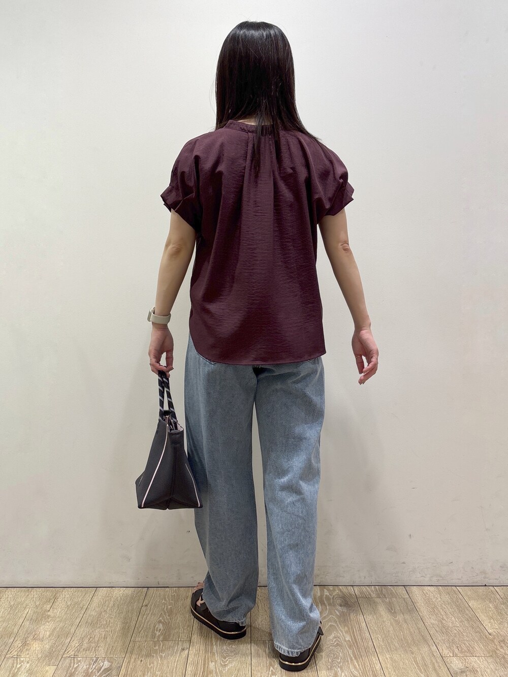 レッド系のシャツ/ブラウス、ブルー系のデニムパンツ、グレー系のトートバッグを着用したレディースの夏コーディネートの3枚目の写真