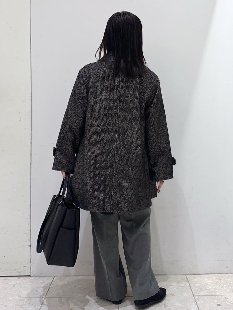 ブラック系のステンカラーコート、ホワイト系のニット/セーター、グレー系のその他パンツを着用したレディースの冬コーディネートの3枚目の写真