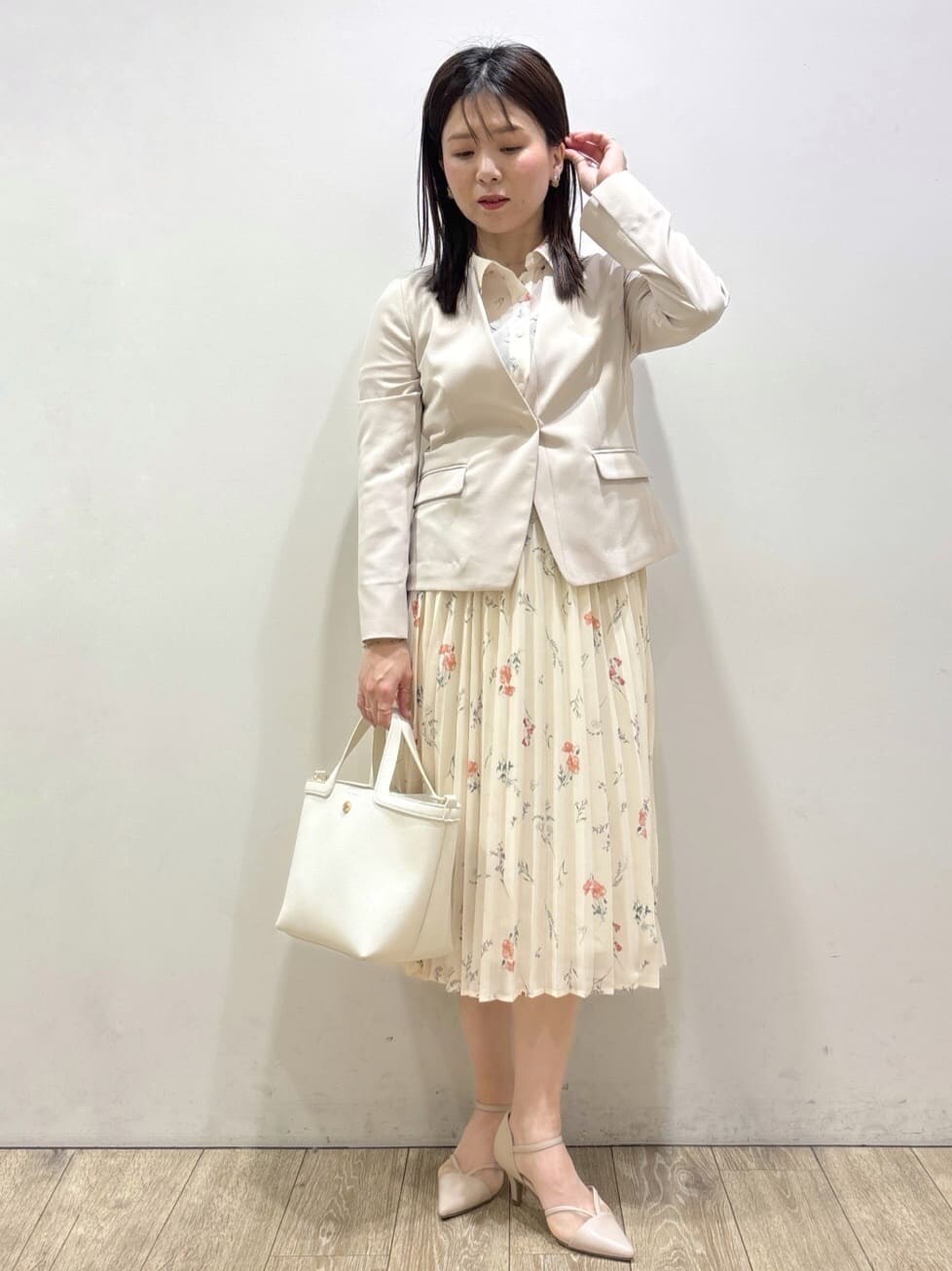 ベージュ系のノーカラージャケット、ベージュ系のパンプス、ホワイト系のショルダーバッグを着用したレディースの春コーディネートの5枚目の写真