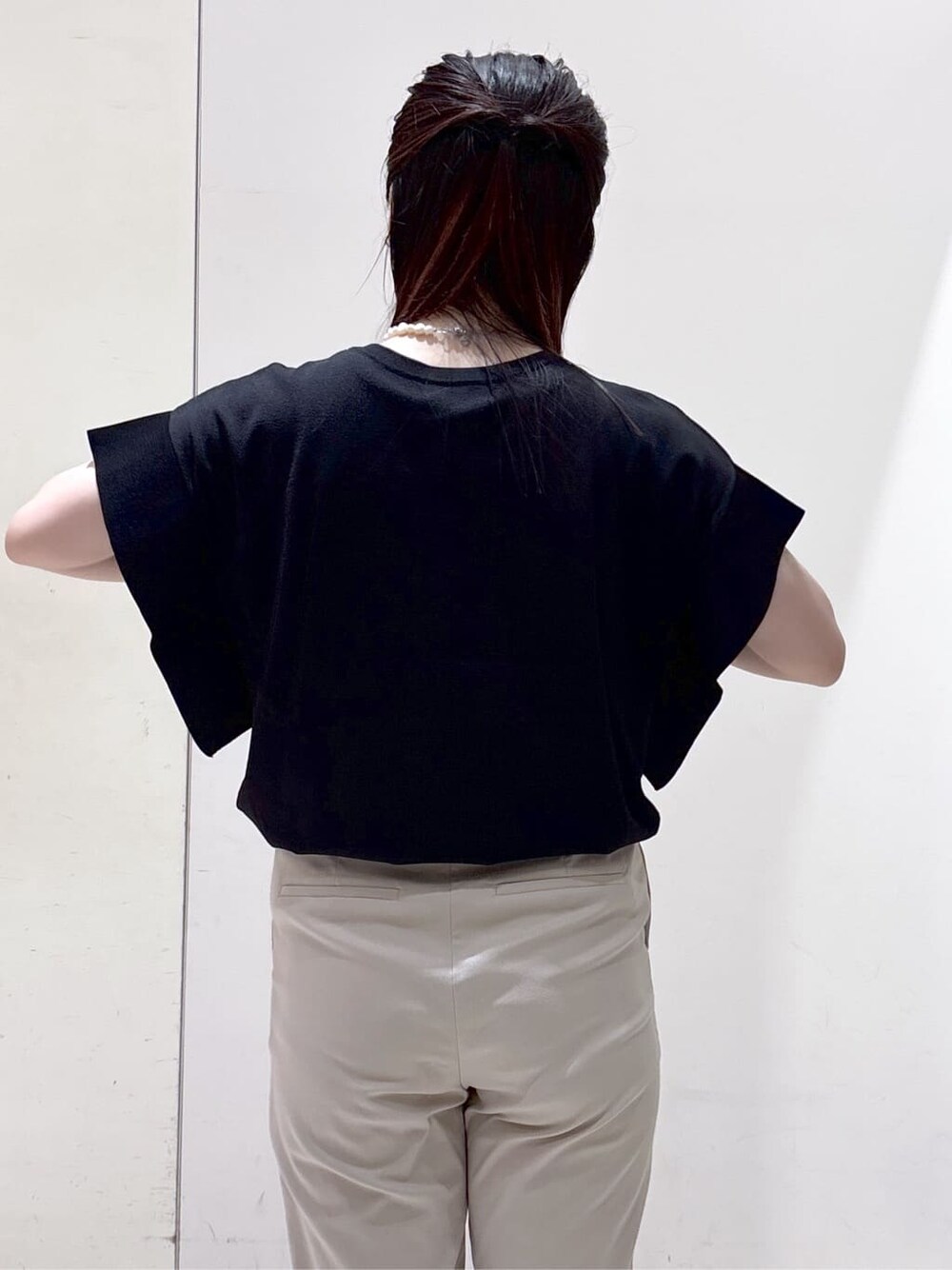 ブラック系のニット/セーター、ベージュ系のその他パンツ、ブラック系のトートバッグを着用したレディースの夏コーディネートの7枚目の写真