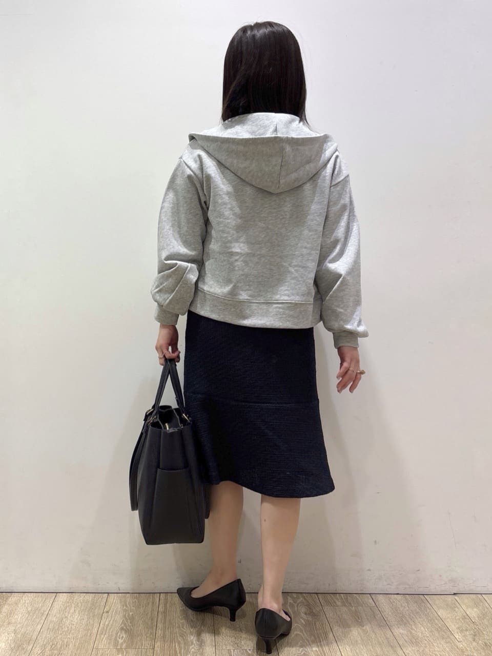 グレー系のパーカー、ホワイト系のシャツ/ブラウス、ブルー系のスカートを着用したレディースの冬コーディネートの3枚目の写真