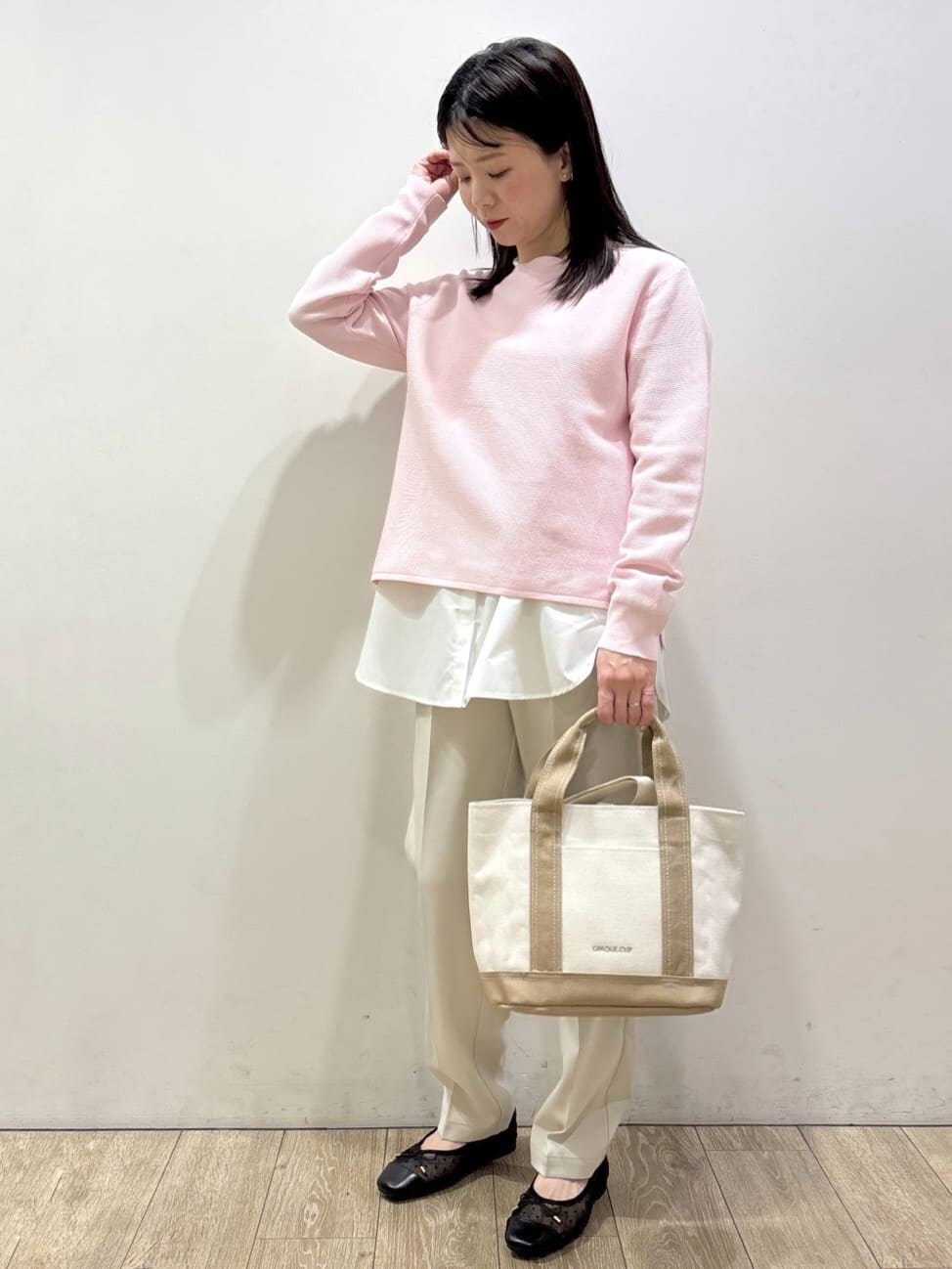 ブラック系のパンプス、ピンク系のニット/セーター、イエロー系のTシャツ/カットソーを着用したレディースの春コーディネートの2枚目の写真