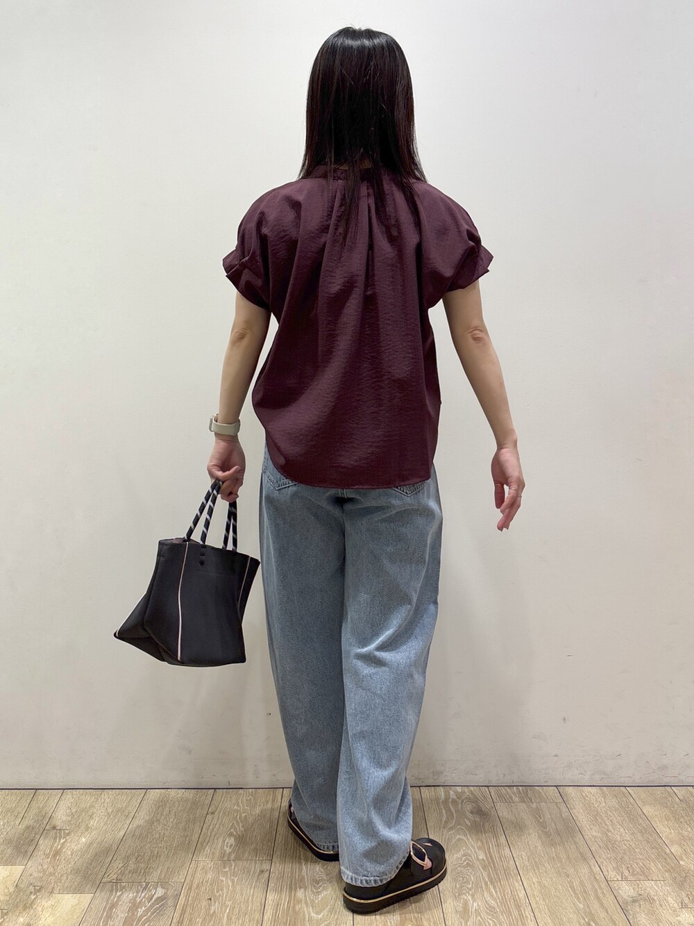 レッド系のシャツ/ブラウス、ブルー系のデニムパンツ、グレー系のトートバッグを着用したレディースの夏コーディネートの3枚目の写真