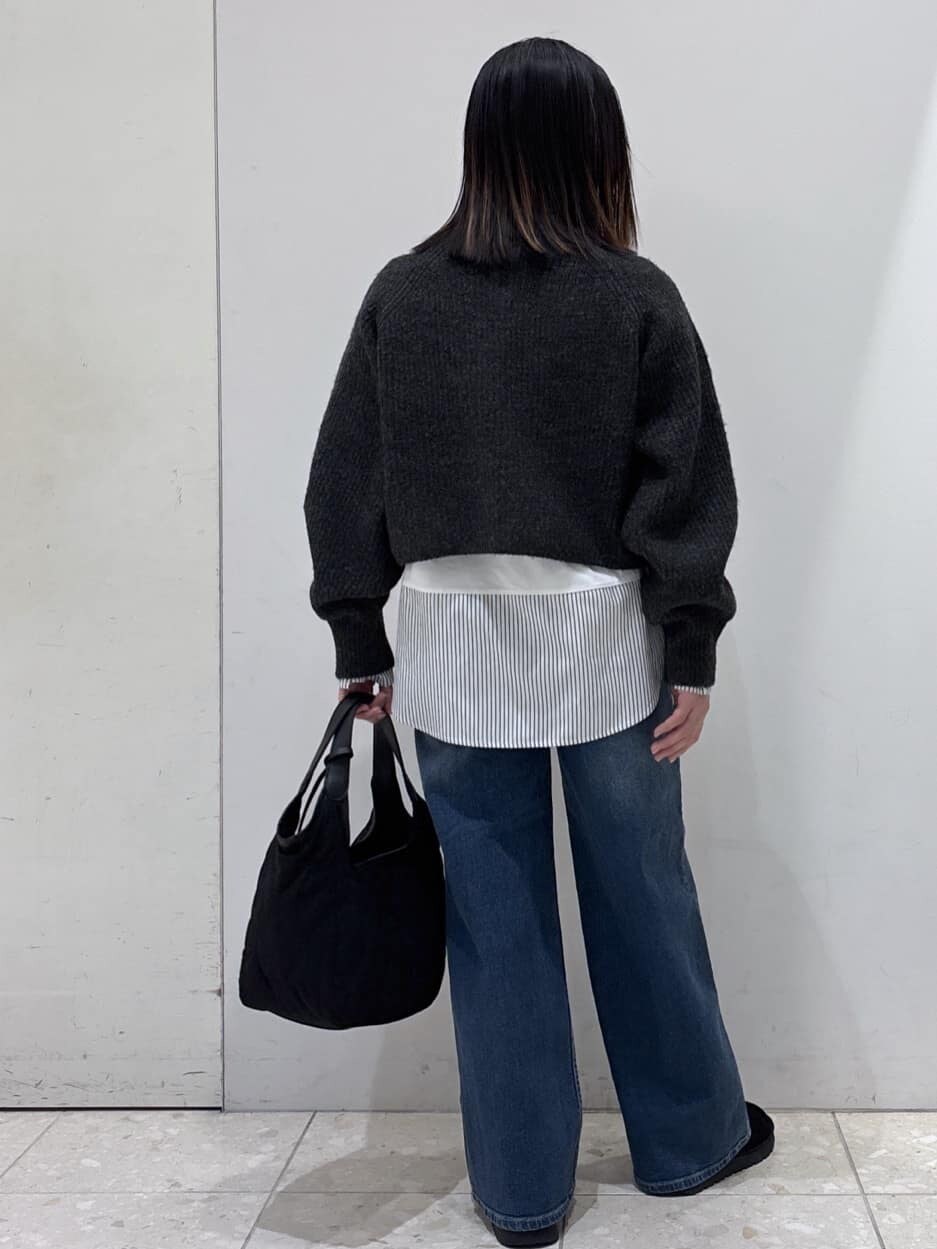 グレー系のニット/セーター、ホワイト系のTシャツ/カットソー、ブルー系のデニムパンツを着用したレディースの冬コーディネートの3枚目の写真