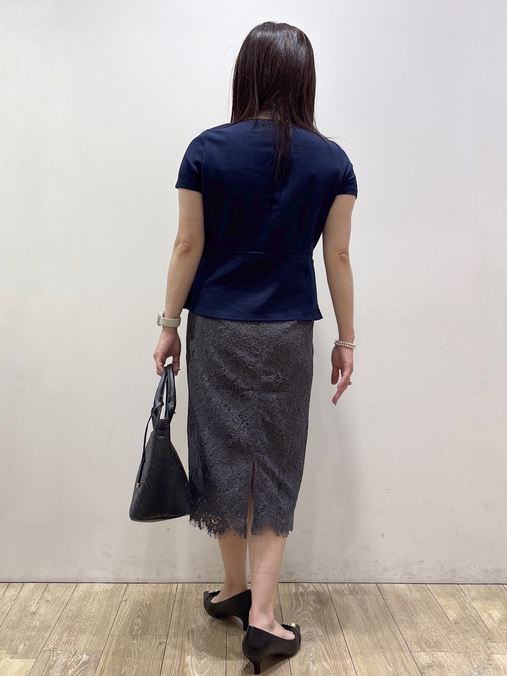 ブルー系のTシャツ/カットソー、グレー系のスカート、ブラック系のトートバッグを着用したレディースの夏コーディネートの3枚目の写真