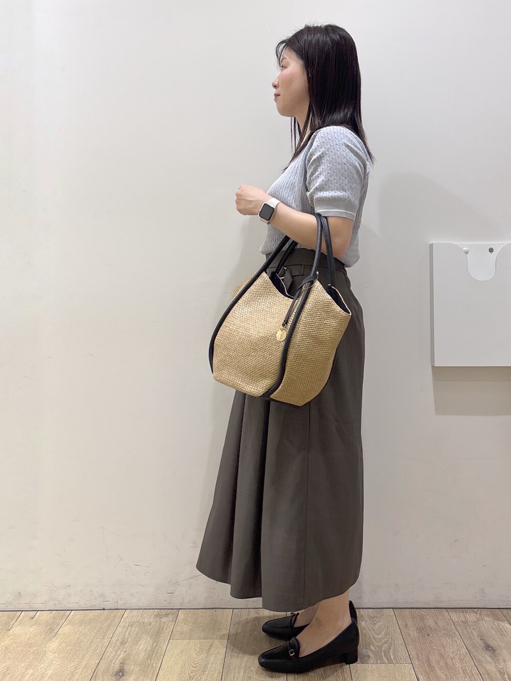 ブラック系のパンプス、ホワイト系のシャツ/ブラウス、ブルー系のニット/セーターを着用したレディースの春コーディネートの6枚目の写真