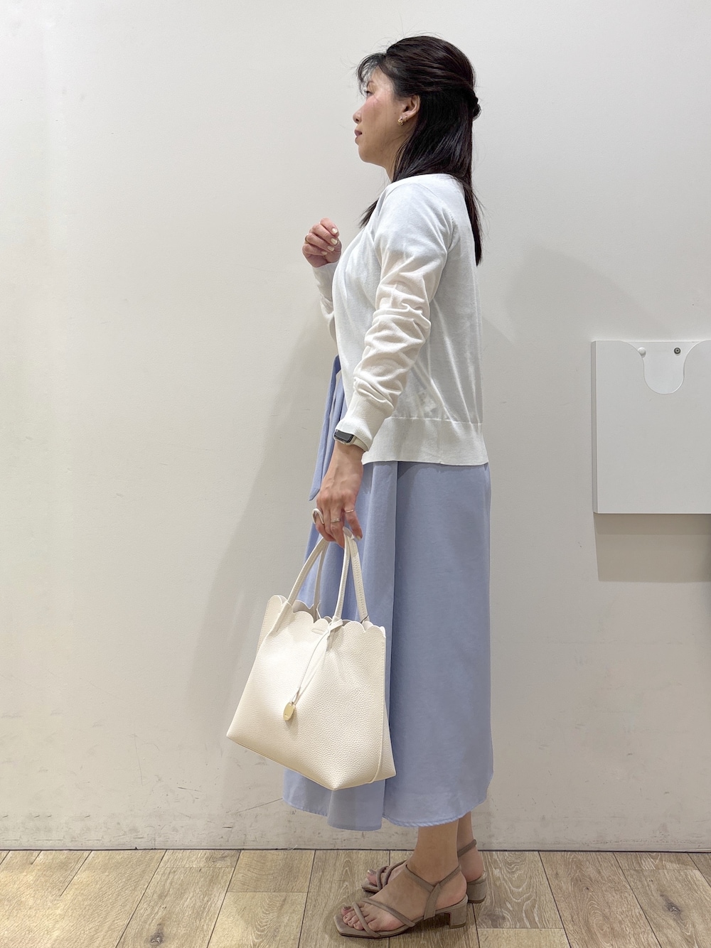 ベージュ系のサンダル、ブルー系のワンピース、ホワイト系のトートバッグを着用したレディースの春コーディネートの6枚目の写真