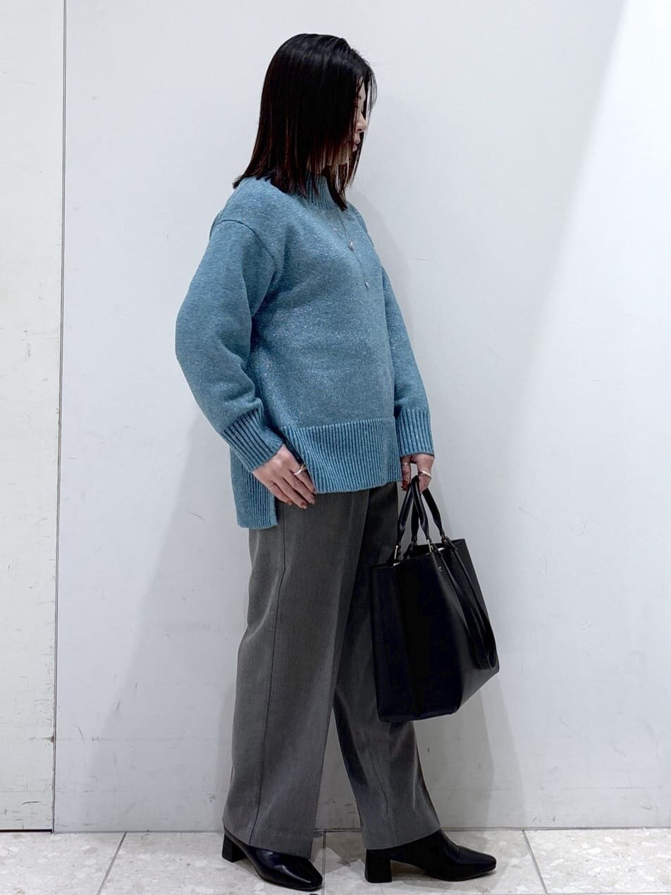 ブルー系のニット/セーター、グレー系のその他パンツ、ブラック系のトートバッグを着用したレディースの冬コーディネートの2枚目の写真