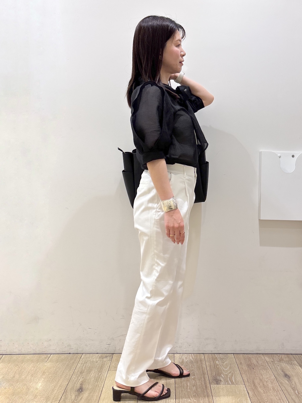 ブラック系のトートバッグ、ブラウン系のサンダル、ホワイト系のその他パンツを着用したレディースの春コーディネートの3枚目の写真