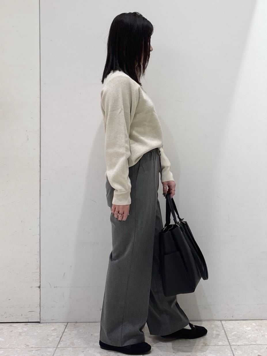 ホワイト系のニット/セーター、グレー系のその他パンツ、ブラック系のトートバッグを着用したレディースの冬コーディネートの4枚目の写真