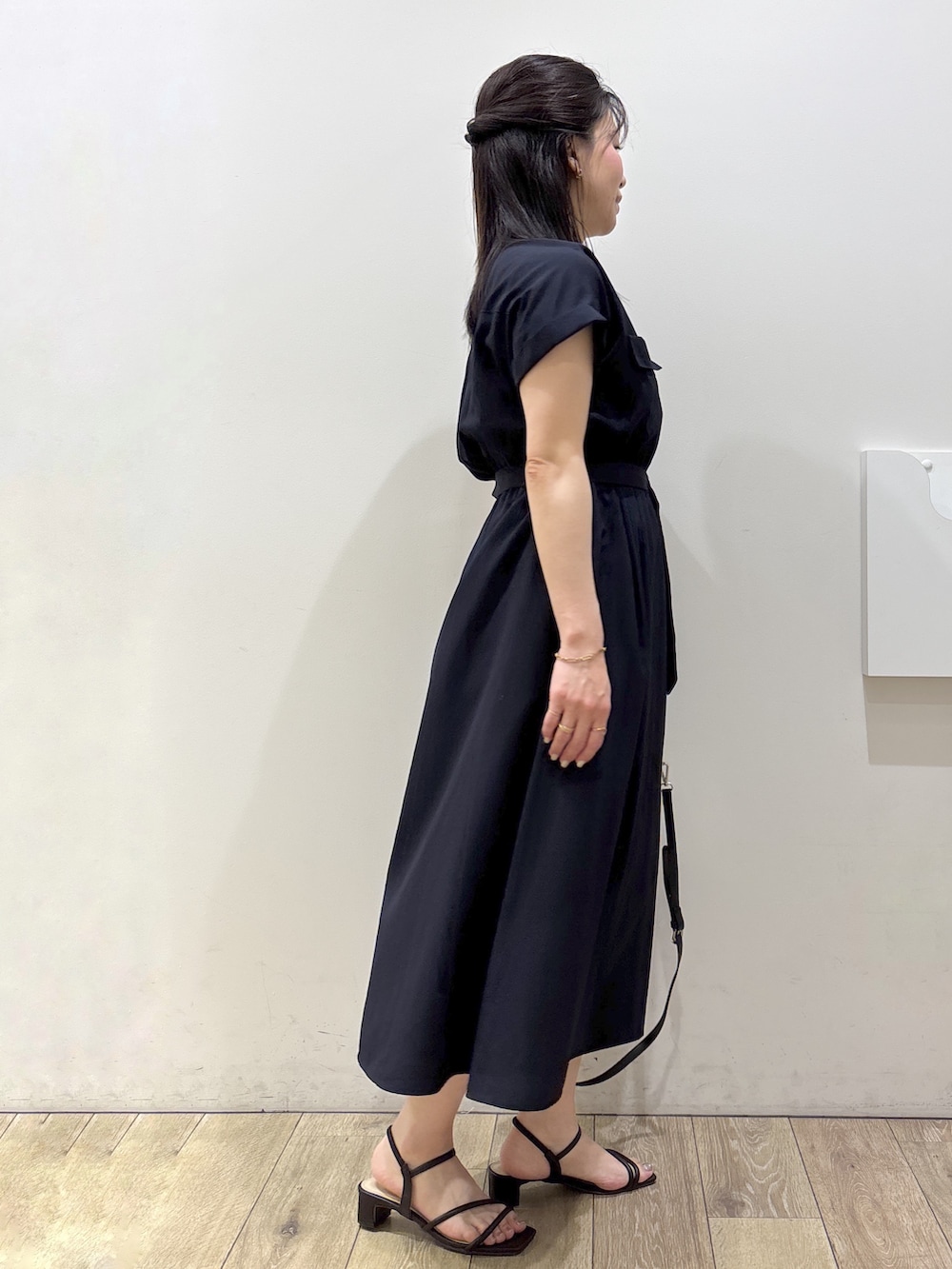ブルー系のワンピース、ブラック系のトートバッグ、ブラウン系のサンダルを着用したレディースの春コーディネートの2枚目の写真