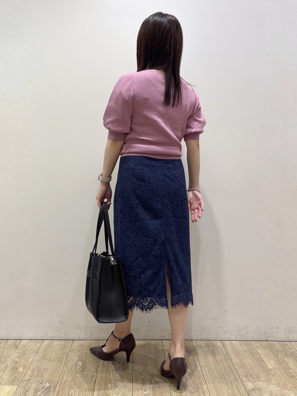 ピンク系のニット/セーター、ブラック系のトートバッグ、レッド系のパンプスを着用したレディースの夏コーディネートの4枚目の写真