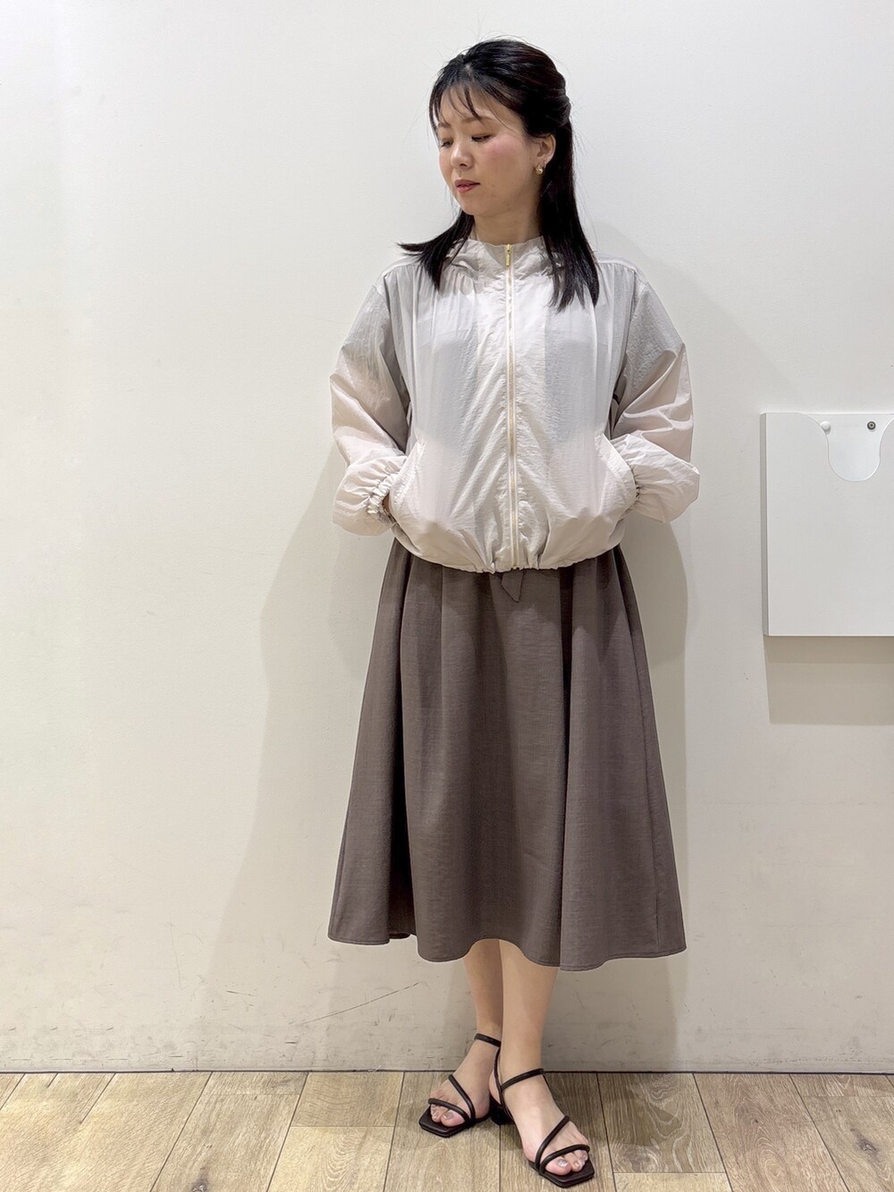 ベージュ系のブルゾン、ブラウン系のワンピース、ブラック系のトートバッグを着用したレディースの春コーディネートの5枚目の写真
