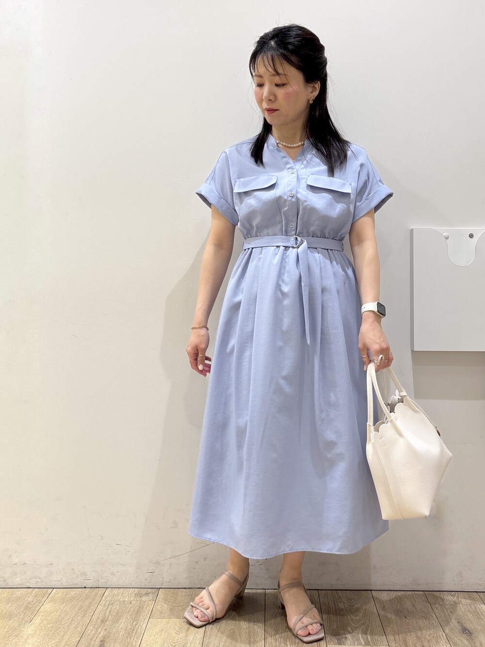 ブルー系のワンピース、ホワイト系のトートバッグ、ベージュ系のサンダルを着用したレディースの春コーディネートの5枚目の写真