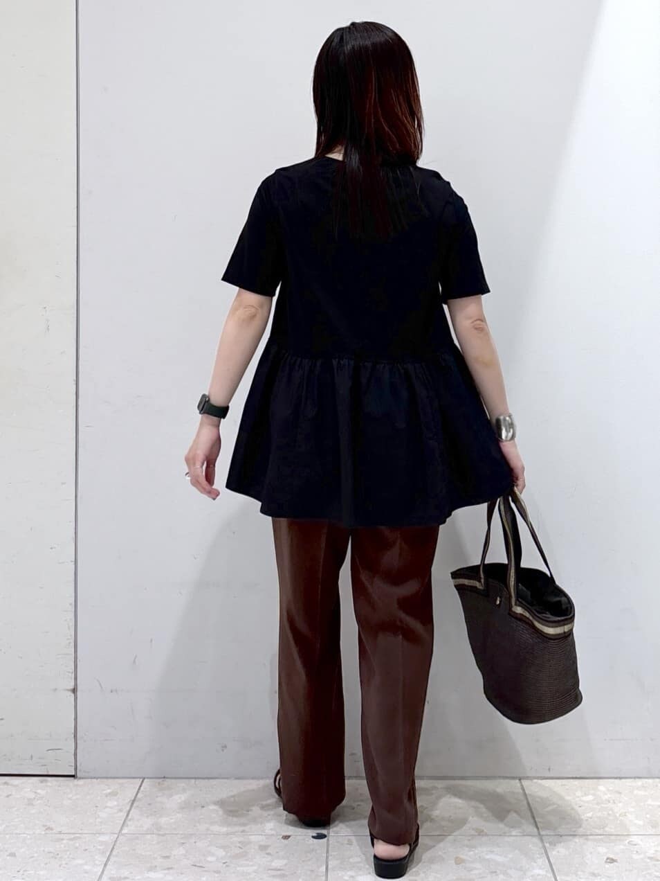 ブラック系のTシャツ/カットソー、ブラウン系のその他パンツ、ブラウン系のトートバッグを着用したレディースの夏コーディネートの3枚目の写真