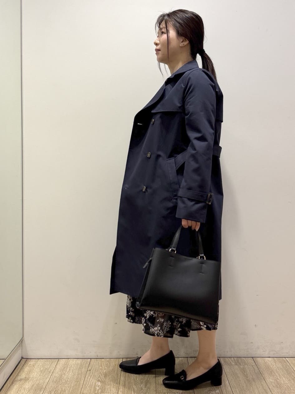 ブルー系のトレンチコート、ブラック系のパンプス、ベージュ系のスカートを着用したレディースの冬コーディネートの4枚目の写真