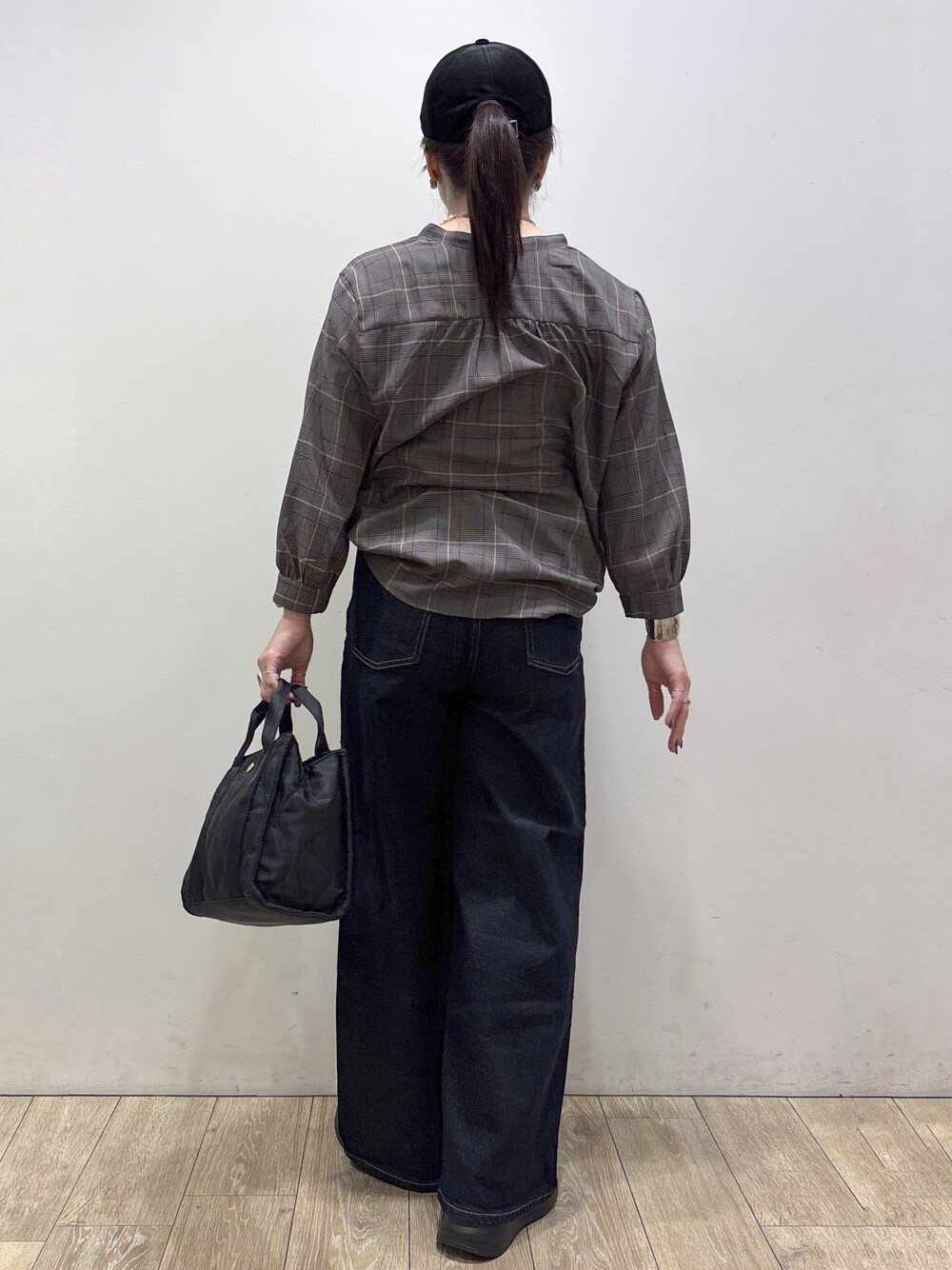 グレー系のシャツ/ブラウス、ブルー系のデニムパンツ、ブラック系のトートバッグを着用したレディースの秋コーディネートの3枚目の写真