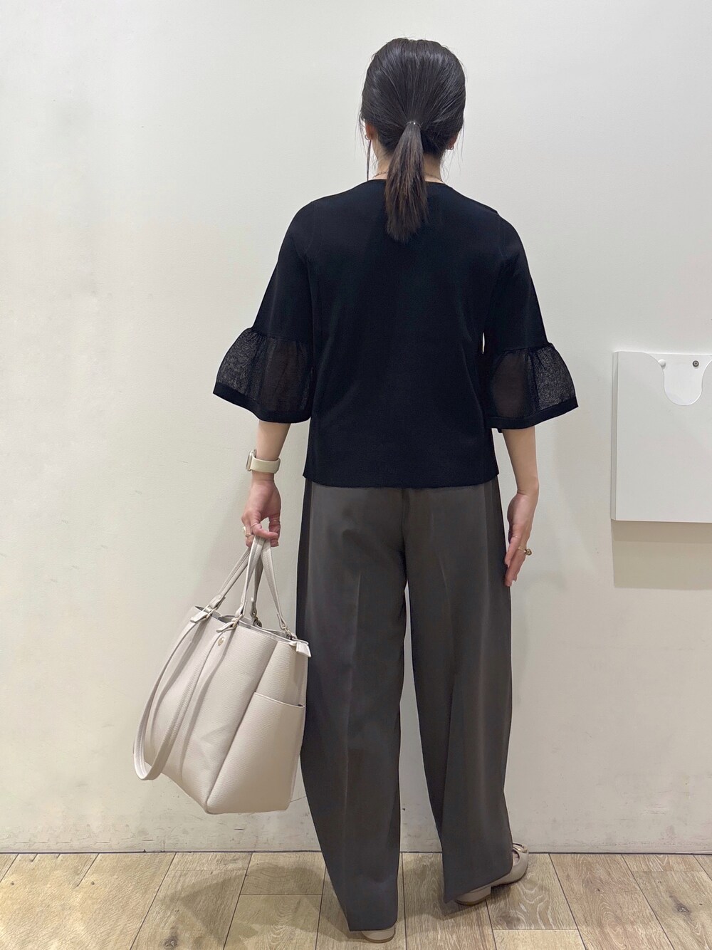 ベージュ系のパンプス、グレー系のカーディガン/ボレロ、ベージュ系のトートバッグを着用したレディースの春コーディネートの3枚目の写真