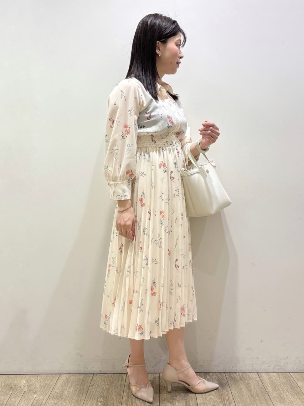 ベージュ系のノーカラージャケット、ベージュ系のパンプス、ホワイト系のショルダーバッグを着用したレディースの春コーディネートの7枚目の写真