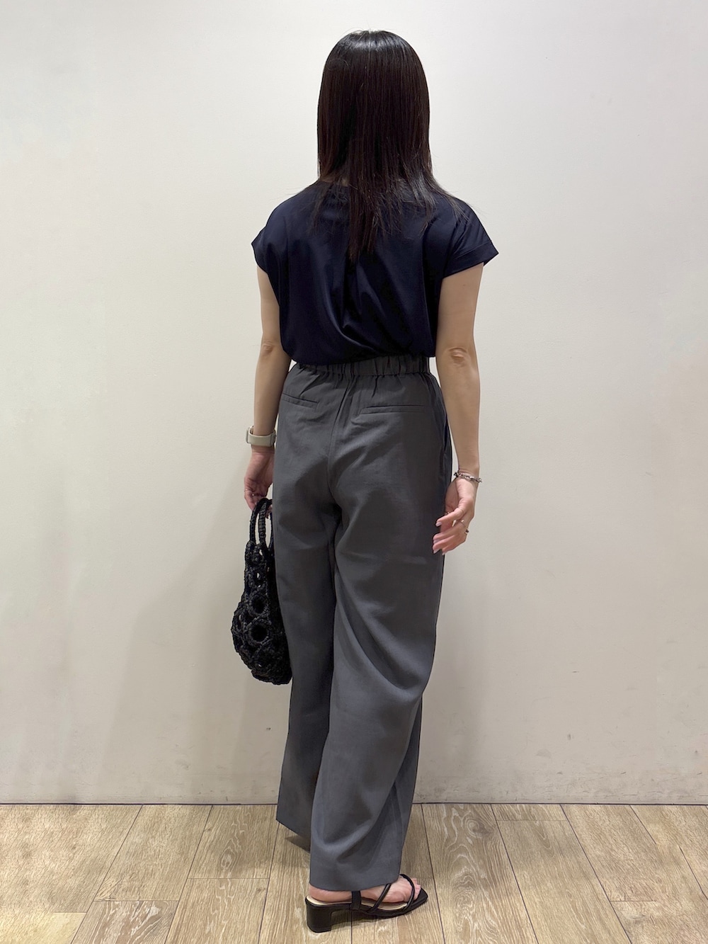 ブルー系のTシャツ/カットソー、グレー系のその他パンツ、ブラック系のハンドバッグを着用したレディースの夏コーディネートの4枚目の写真