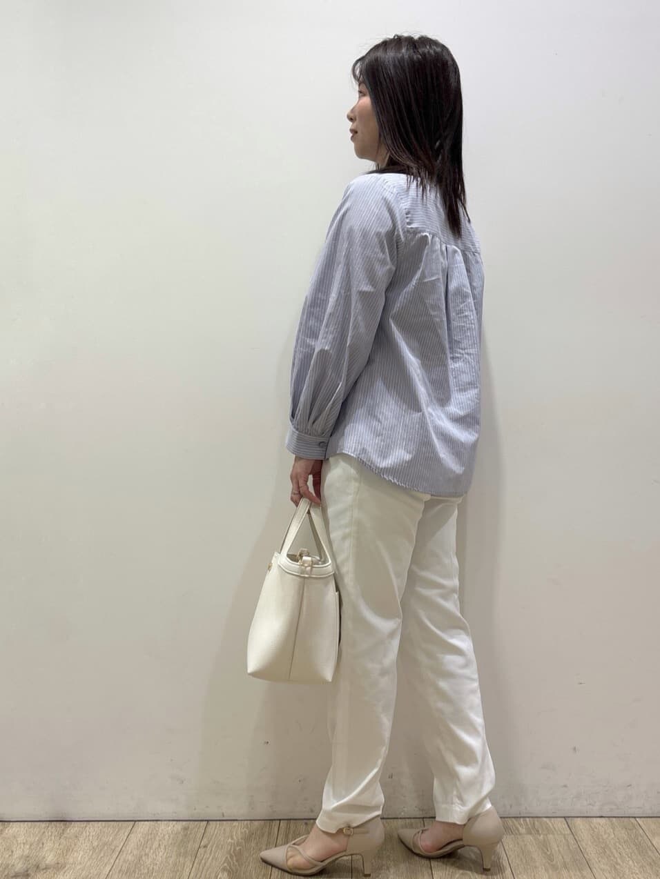 ベージュ系のパンプス、ブルー系のシャツ/ブラウス、ホワイト系のショルダーバッグを着用したレディースの春コーディネートの5枚目の写真