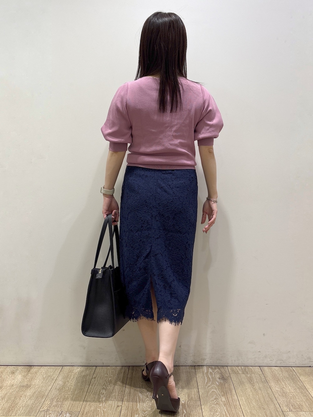 ピンク系のニット/セーター、ブラック系のトートバッグ、レッド系のパンプスを着用したレディースの夏コーディネートの3枚目の写真