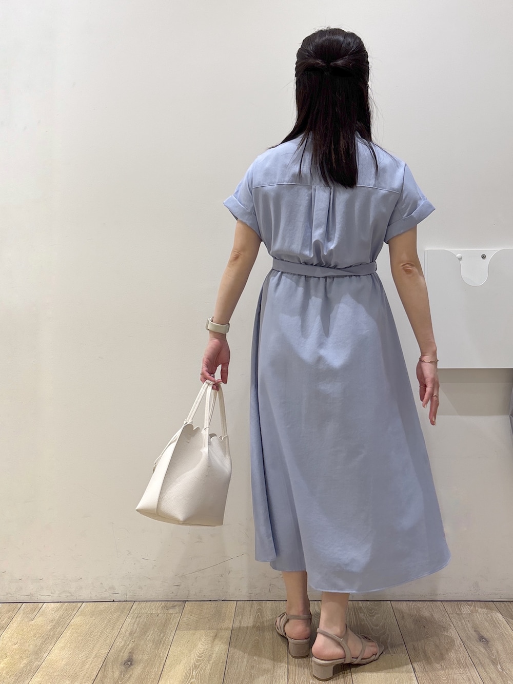 ブルー系のワンピース、ホワイト系のトートバッグ、ベージュ系のサンダルを着用したレディースの春コーディネートの3枚目の写真