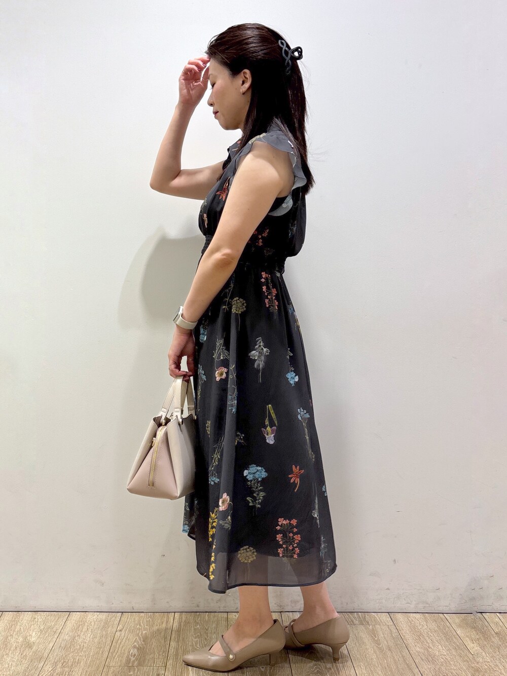 グレー系のワンピース、ベージュ系のボストンバッグ、ベージュ系のパンプスを着用したレディースの夏コーディネートの4枚目の写真