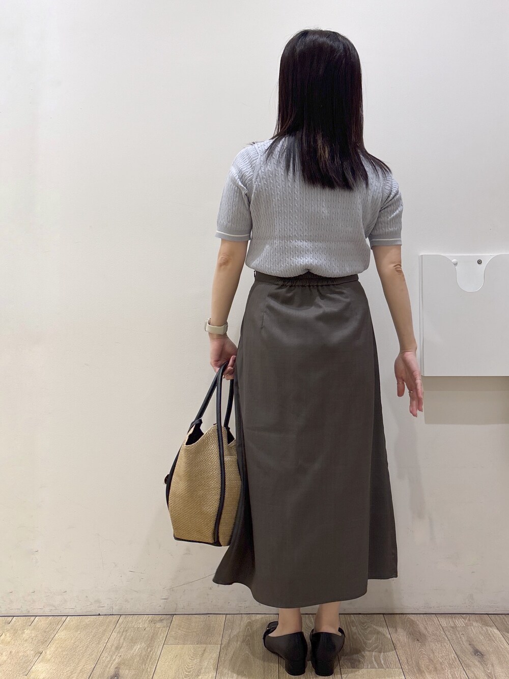 ブルー系のニット/セーター、ベージュ系のトートバッグ、ブラック系のパンプスを着用したレディースの春コーディネートの5枚目の写真