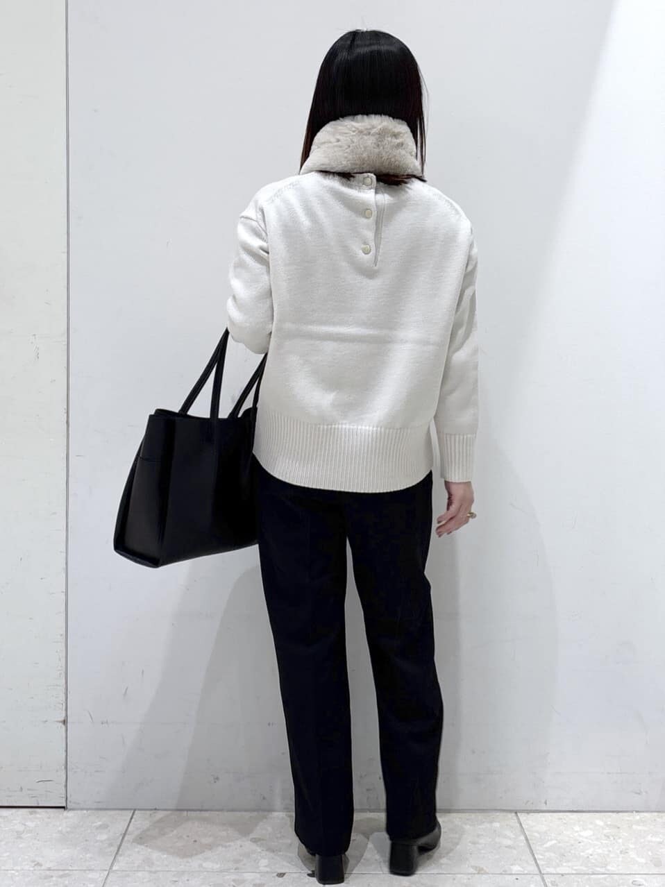 ホワイト系のニット/セーター、ブラック系のその他パンツ、ブラック系のトートバッグを着用したレディースの冬コーディネートの3枚目の写真