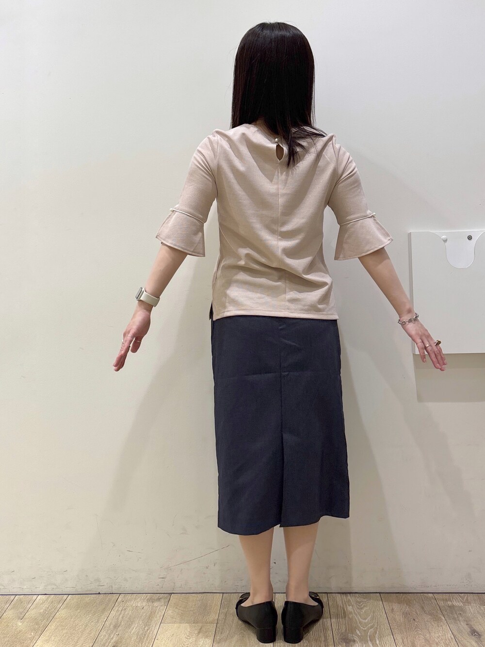 ブラック系のパンプス、ブラック系のトートバッグ、ブルー系のスカートを着用したレディースの春コーディネートの10枚目の写真