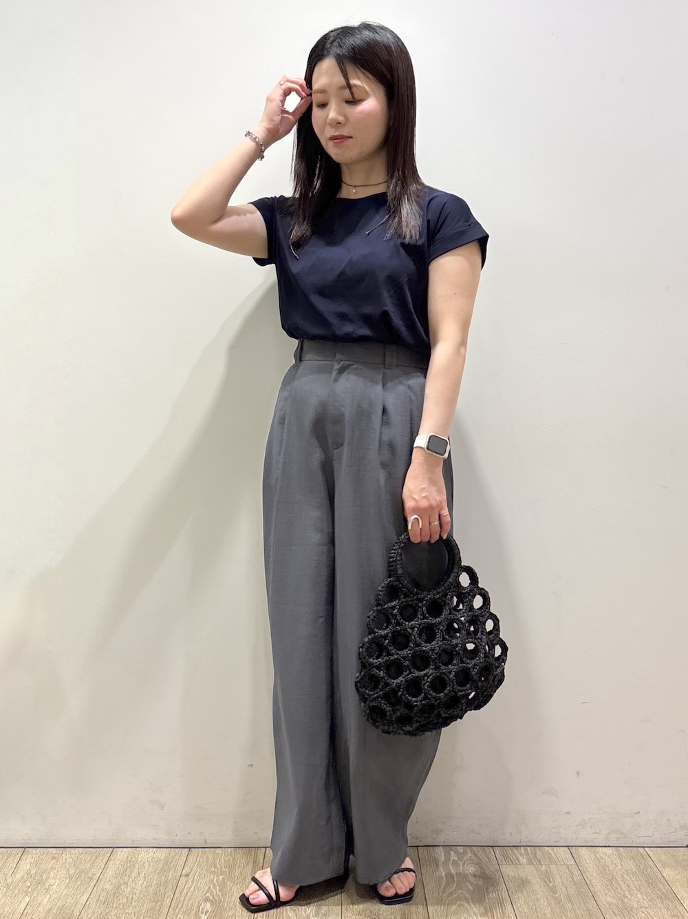 ブルー系のTシャツ/カットソー、グレー系のその他パンツ、ブラック系のハンドバッグを着用したレディースの夏コーディネートの2枚目の写真