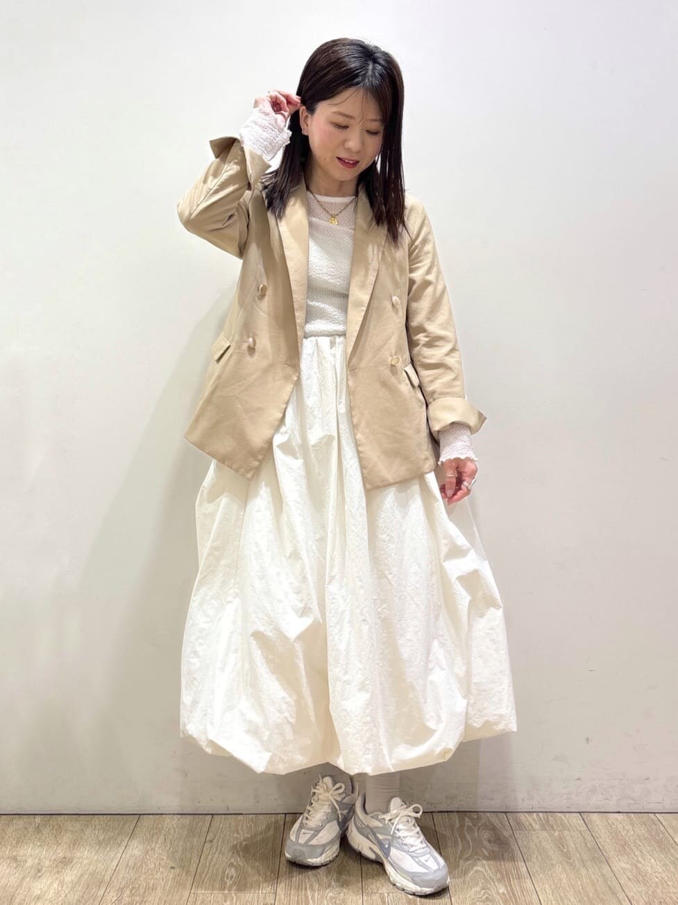 ホワイト系のTシャツ/カットソー、ベージュ系のテーラードジャケット、ホワイト系のスカートを着用したレディースの春コーディネートの6枚目の写真