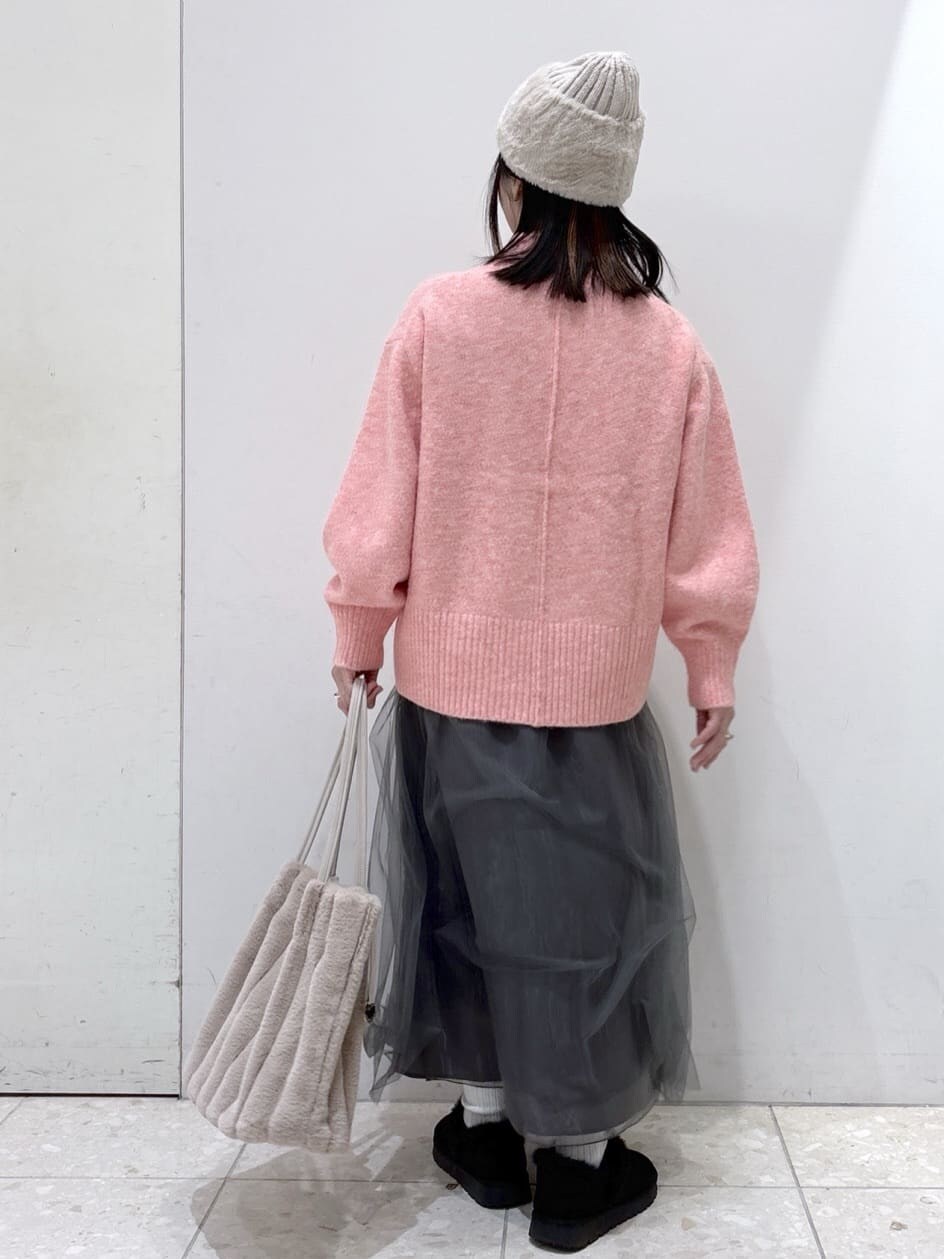 ピンク系のニット/セーター、グレー系のスカート、ベージュ系のトートバッグを着用したレディースの冬コーディネートの3枚目の写真