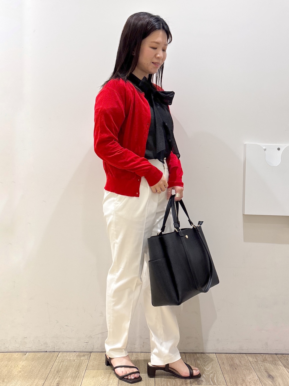 ブラック系のトートバッグ、ブラウン系のサンダル、ホワイト系のその他パンツを着用したレディースの春コーディネートの6枚目の写真