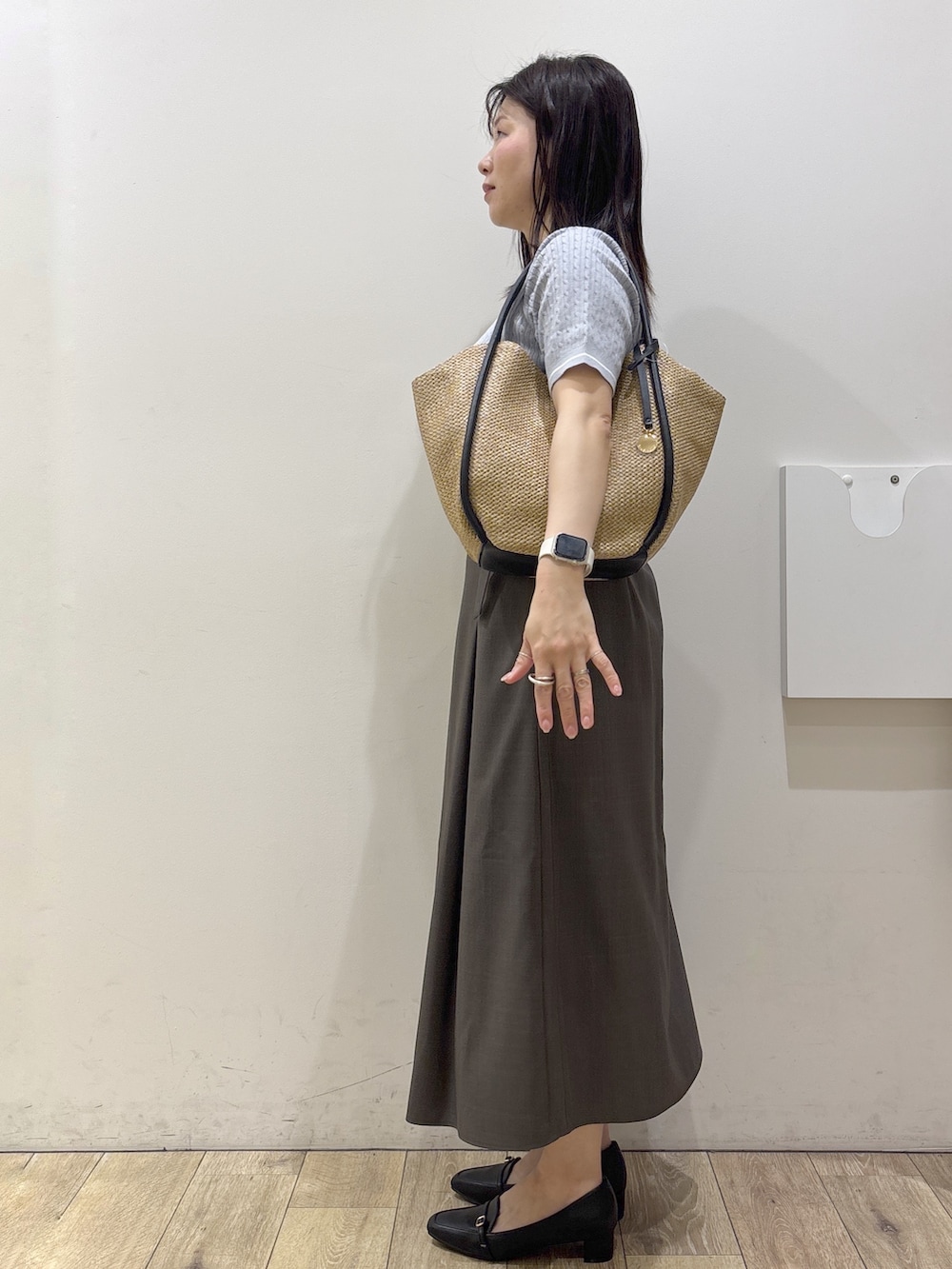 ブラック系のパンプス、ホワイト系のシャツ/ブラウス、ブルー系のニット/セーターを着用したレディースの春コーディネートの3枚目の写真