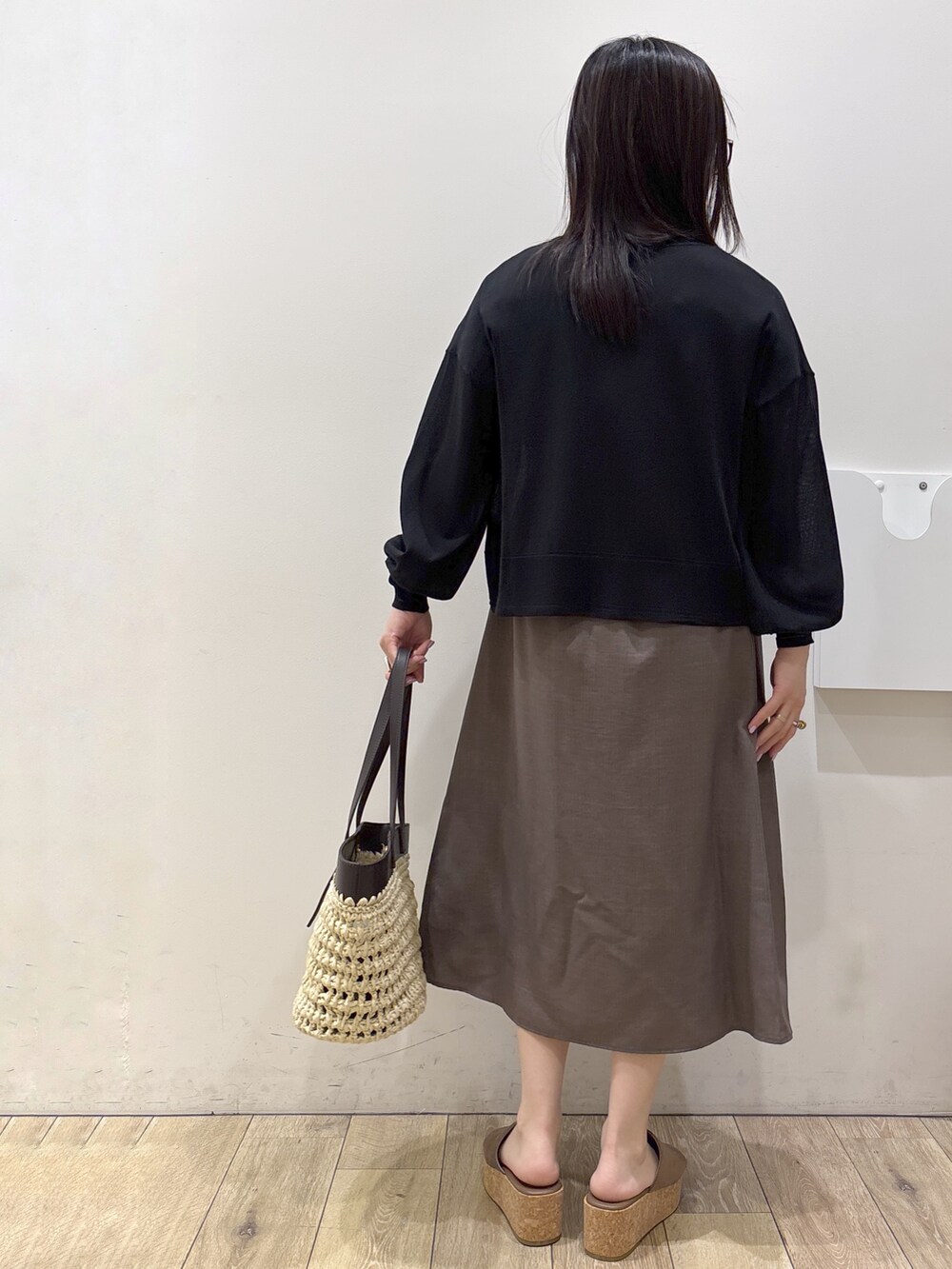 ブラウン系のワンピース、ブラウン系のトートバッグ、ベージュ系のサンダルを着用したレディースの夏コーディネートの3枚目の写真