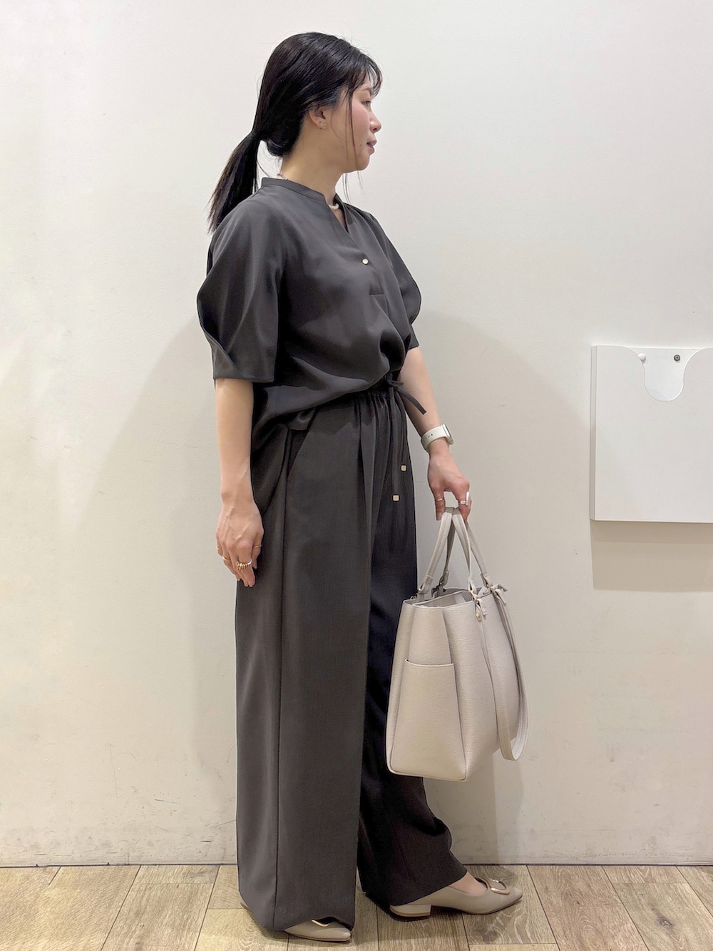 ベージュ系のパンプス、グレー系のカーディガン/ボレロ、ベージュ系のトートバッグを着用したレディースの春コーディネートの2枚目の写真