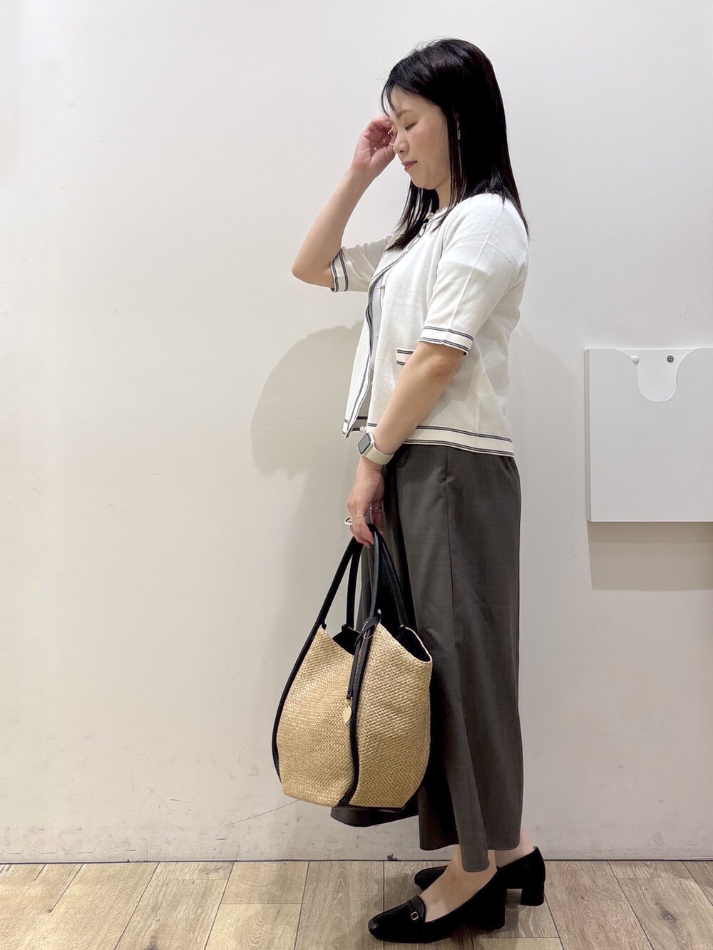 ブラック系のパンプス、ホワイト系のカーディガン/ボレロ、ホワイト系のシャツ/ブラウスを着用したレディースの春コーディネートの4枚目の写真
