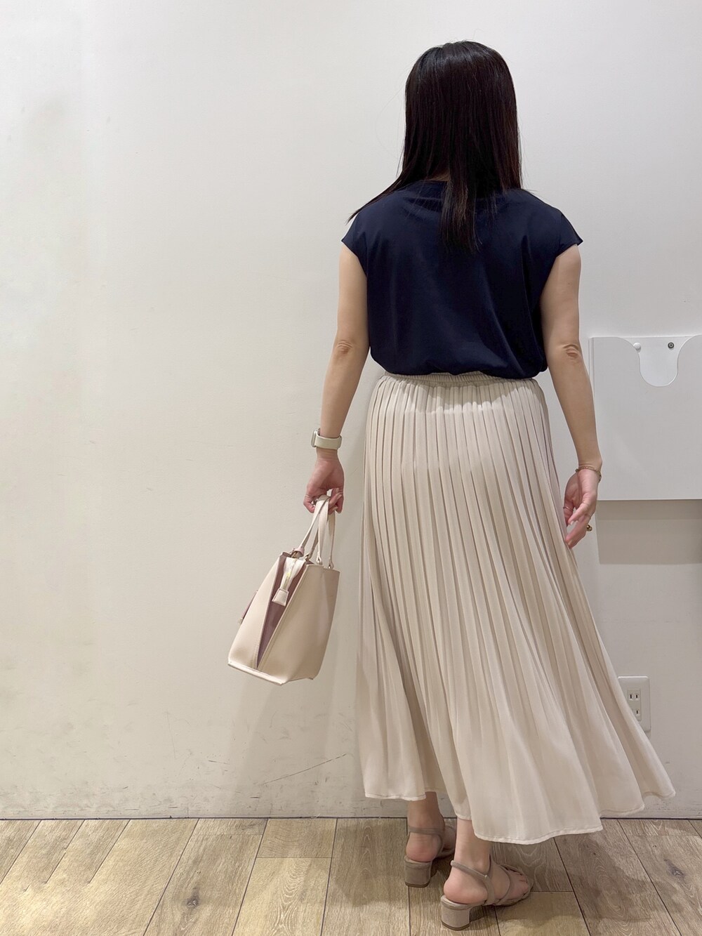 ベージュ系のワンピース、ベージュ系のスカート、ベージュ系のトートバッグを着用したレディースの春コーディネートの3枚目の写真