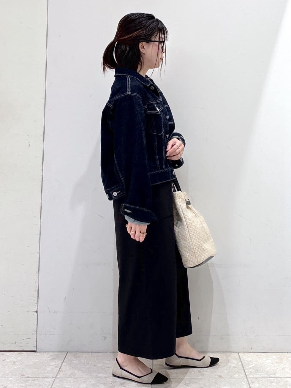 ブルー系のデニムジャケット、ホワイト系のTシャツ/カットソー、ブラック系のスカートを着用したレディースの春コーディネートの2枚目の写真