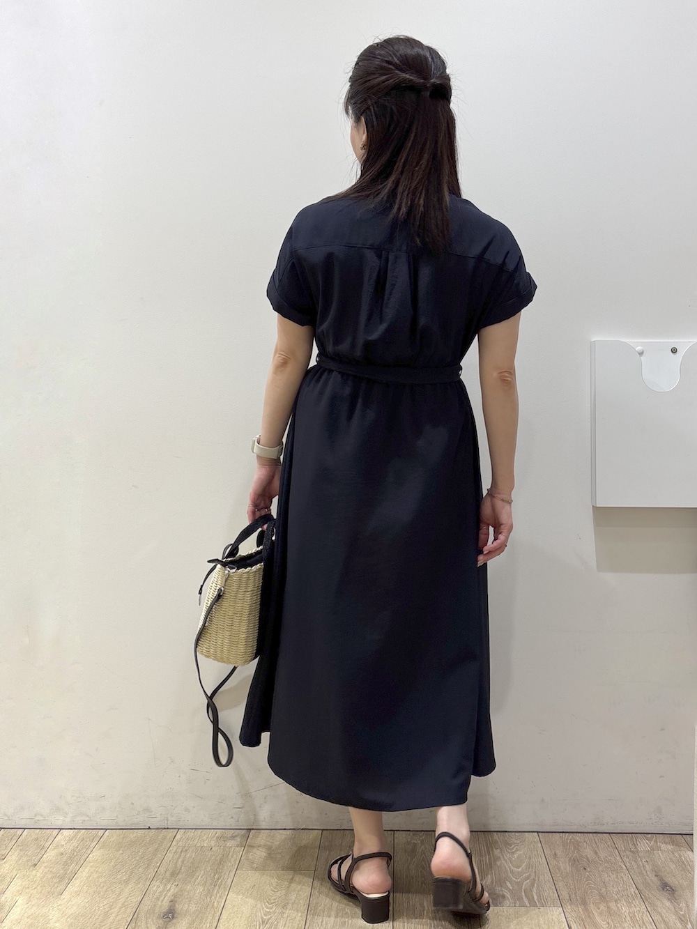 ブルー系のワンピース、ブラック系のトートバッグ、ブラウン系のサンダルを着用したレディースの春コーディネートの3枚目の写真