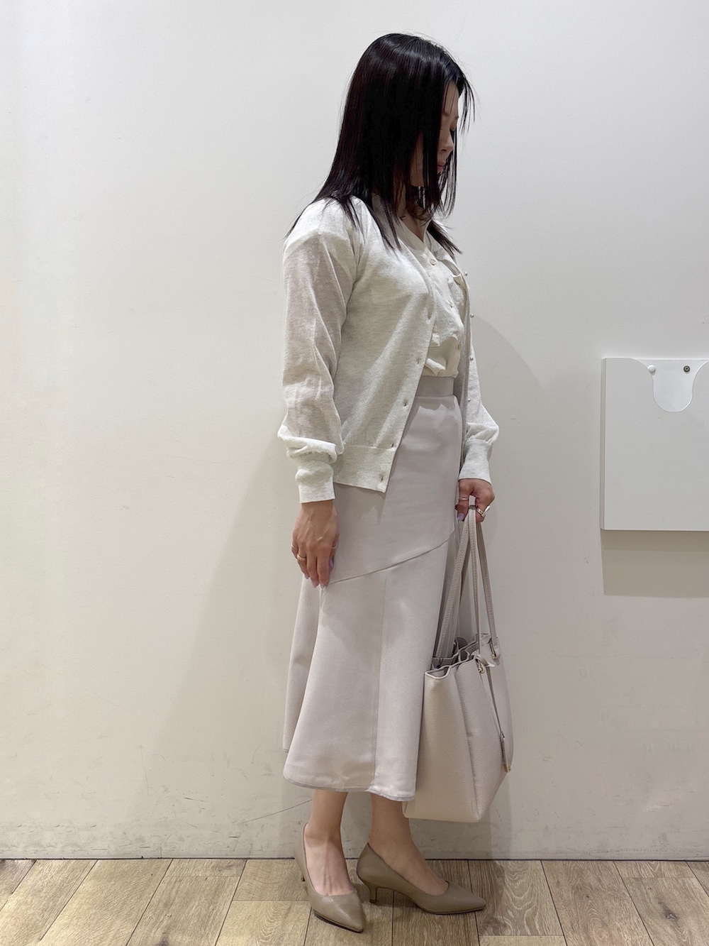 ホワイト系のカーディガン/ボレロ、ホワイト系のシャツ/ブラウス、ベージュ系のスカートを着用したレディースの夏コーディネートの5枚目の写真