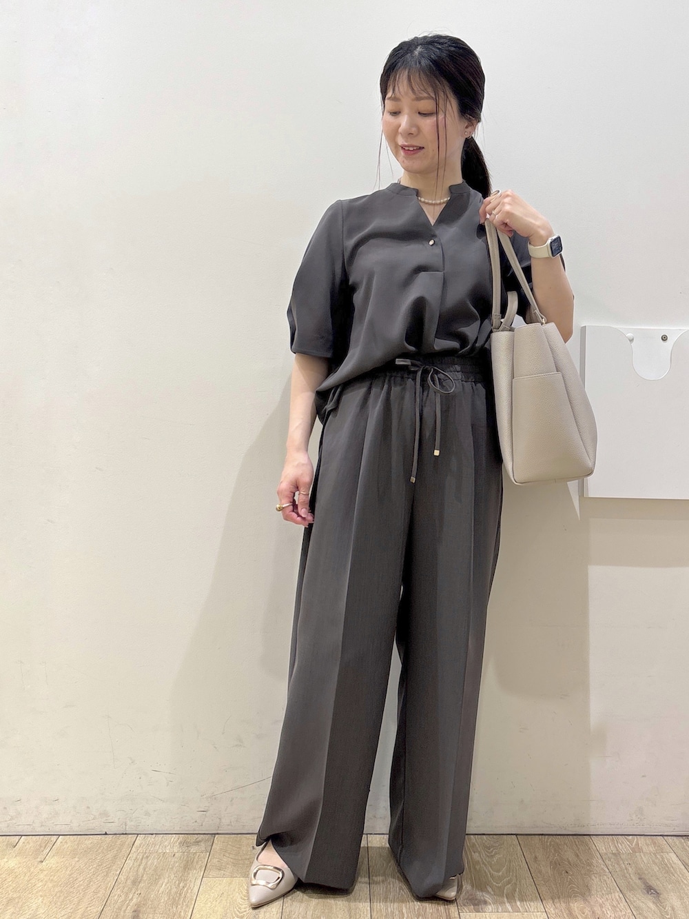 ベージュ系のパンプス、グレー系のカーディガン/ボレロ、ベージュ系のトートバッグを着用したレディースの春コーディネートの7枚目の写真