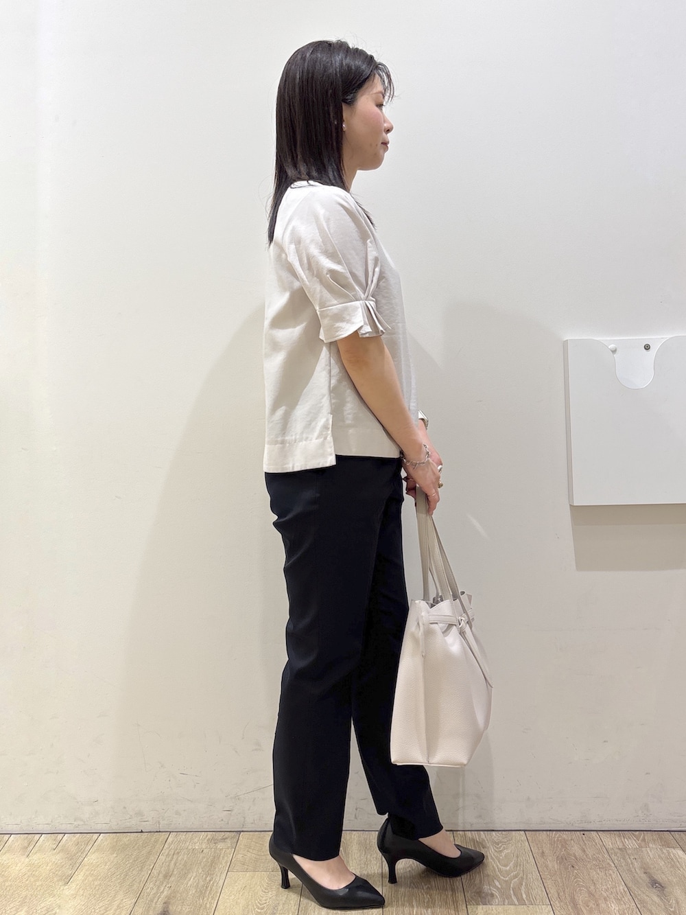 ブラック系のパンプス、グレー系のトートバッグ、ブルー系のその他パンツを着用したレディースの春コーディネートの2枚目の写真