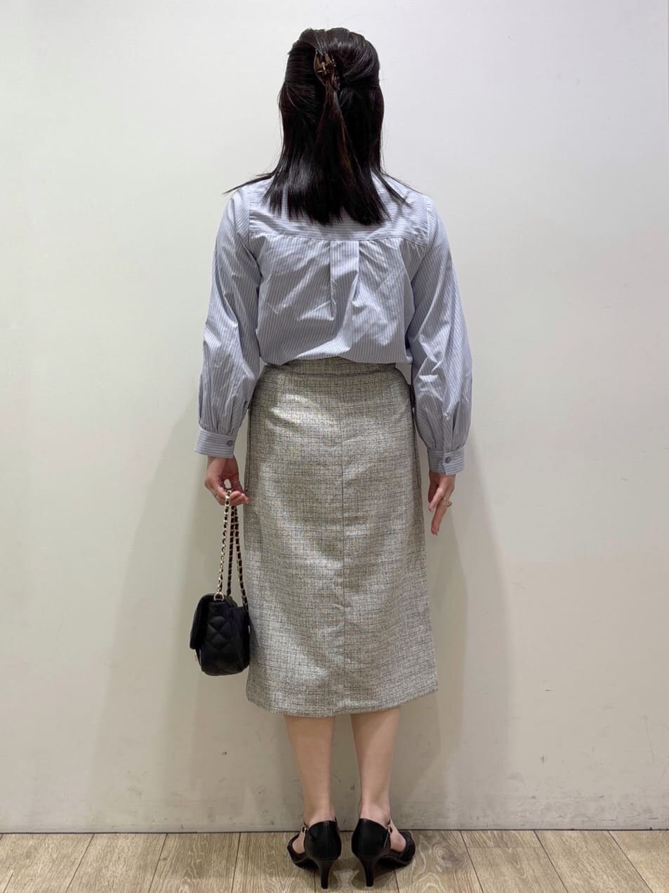 ブラック系のパンプス、ベージュ系のスカート、ブルー系のシャツ/ブラウスを着用したレディースの春コーディネートの3枚目の写真